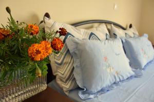 塞萨洛尼基Elisavet apartment的一张带白色枕头的床和橙花花花瓶