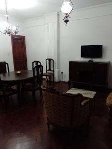 罗萨里奥Cómo en casa的一间带桌椅和电视的用餐室