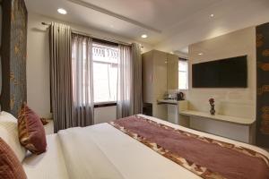 新德里Hotel Kaca Inn-by Haveliya Hotels的酒店客房,配有床和电视