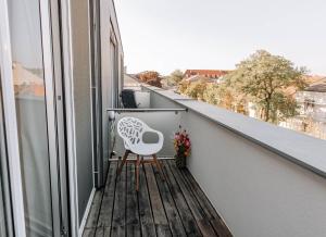 施韦夏特HEINhotel vienna airport的白色椅子坐在带窗户的阳台