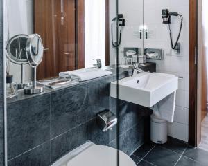 施韦夏特HEINhotel vienna airport的一间带水槽、卫生间和镜子的浴室