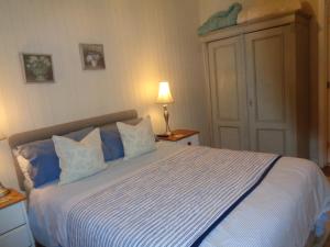 埃文河畔斯特拉特福Log Cabin, Conveniently Situated halfway between Stratford and Warwick的一间卧室配有一张带蓝白色床单的大床