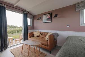 金斯林Barley Shepherd Hut - Snettisham Meadows的客厅配有沙发和桌子