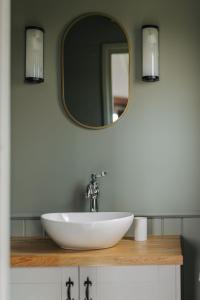金斯林Barley Shepherd Hut - Snettisham Meadows的浴室设有白色水槽和镜子