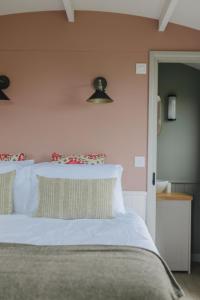 金斯林Barley Shepherd Hut - Snettisham Meadows的一间卧室配有带白色床单和枕头的床。