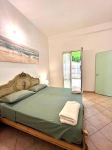 菲纳莱利古雷Casa Rosa的一间卧室设有一张绿色大床和一个窗户。