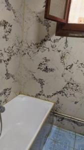 伊斯梅利亚Ismailia - Elnouras compound的浴室配有白色浴缸和大理石墙。