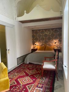 突尼斯Maison typique de la médina的一间卧室配有一张大床和红色地毯。