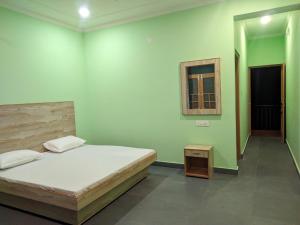 达兰萨拉Happy home stay, Dharamshala的一间卧室设有一张大床和一个窗户。
