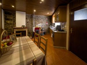 布拉干萨Casa do Souto - Nature & Experiences - Turismo Rural的厨房以及带水果篮的桌子的用餐室。
