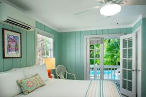 基韦斯特西风旅馆的卧室设有白色的床和绿色的墙壁