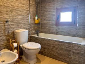 布拉干萨Casa do Souto - Nature & Experiences - Turismo Rural的浴室配有卫生间、浴缸和水槽。