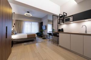 卢森堡The Central Kirchberg - Smart ApartHotel的酒店客房带一张床和一个厨房