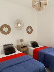 科尔多瓦CASA ALQUILER TEMPORAL VILLA CABRERA的一间设有两张床的客房和墙上的镜子