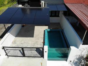 甘文丁Zen Retreat Glass Pool Villa的享有带蓝色遮阳篷的游泳池的顶部景致