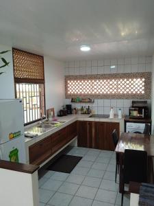 卡宴MO TI KOTÉ的厨房配有木制橱柜和桌子。
