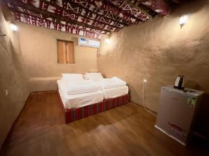 阿尔哈姆拉AL Hamra Heritage Inn的小房间设有两张床和一部电话