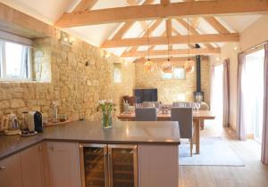 布罗德韦Lily Rose Cottage的厨房配有桌子和石墙