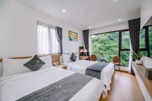 吉婆岛CAT BA ECO HOTEL的酒店客房设有两张床和大窗户。