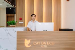 吉婆岛CAT BA ECO HOTEL的站在桌子后面的手提电脑的人