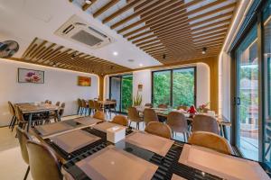 吉婆岛CAT BA ECO HOTEL的用餐室设有桌椅和窗户。