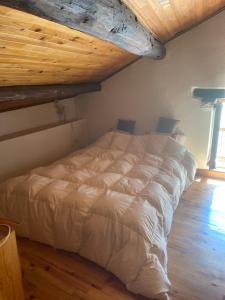 Beaunechalet st michel de maurienne的卧室内的白色床,设有木制天花板