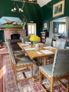 West DeanThe Selsey Arms的一间带木桌和壁炉的用餐室