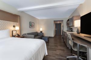 坦帕温盖特温德姆坦帕USF/布什花园酒店的酒店客房设有床和客厅。