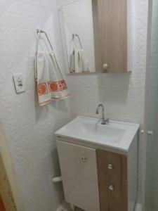 伊塔佩马Pequeno, más aconchegante的浴室设有白色水槽和镜子