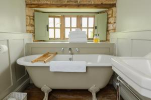 奇平卡姆登The Ebrington Arms的浴室配有白色浴缸和水槽