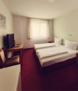 纽伦堡City Hotel Bauer mit Aufzug with elevator的酒店客房设有两张床和电视。