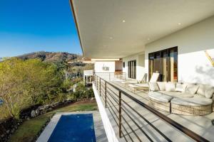 普拉亚埃尔莫萨Casa Blanca的带阳台的房屋,设有游泳池