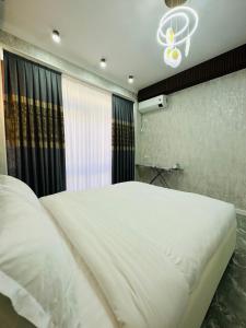 TürkistanKERUEN SARAY APARTMENTS 20/2的卧室设有一张白色大床和一扇窗户。