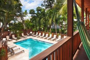 基韦斯特岛城酒店的一个带椅子的阳台的游泳池和一个泳池景