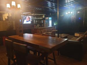 KigoRosa Negra Uganda的一间带木桌和电视的用餐室