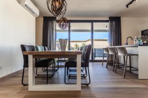 棕榈滩Tuscany Residence Aruba的厨房以及带桌椅的用餐室。