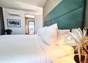 棕榈滩Tuscany Residence Aruba的卧室配有带白色枕头的大床