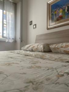 罗马Distretto 14的一间卧室配有带枕头的床铺和绘画