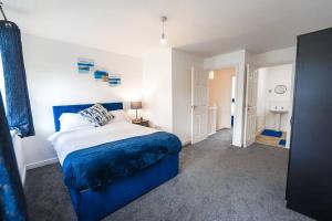 伯明翰The Luxury Inn, Birmingham的一间带蓝色和白色床的卧室以及一间浴室。