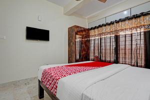 班加罗尔Oyo Flagship Sri Chowdeshwari Boarding And Lodging的一间卧室配有一张带红色毯子的大床