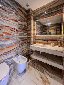卡塔尼亚Ricci Palace Suites的浴室配有盥洗池、卫生间和镜子。