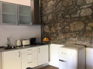 科维良卡萨杜瑞弗希奥公寓的厨房配有白色橱柜和石墙