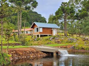 乌鲁佩马Chalé do Lago Urupema SC的湖畔的一座房子,有瀑布