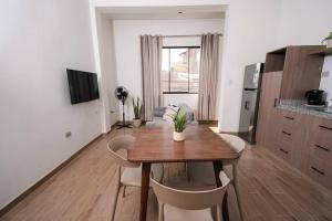 塔拉波托CASA MONA 2 - Apartamento en Tarapoto的厨房以及带木桌和椅子的用餐室。