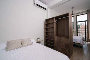 塔拉波托CASA MONA 2 - Apartamento en Tarapoto的一间卧室配有一张大床和木柜