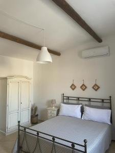 SternatiaAgriturismo Masseria Chicco Rizzo的一间卧室配有一张带白色床单和一盏灯的床。