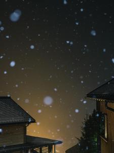 施图本阿尔贝格阿尔山洛奇酒店的一片星空的夜晚,房子的屋顶上下着雪