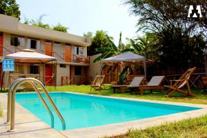 IllimoEcolodge Huaca Piedra的酒店前的游泳池配有椅子和遮阳伞