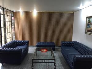 波苏阿莱格里Fenix Hotel Pouso Alegre的客厅配有2张蓝色的沙发和1张桌子