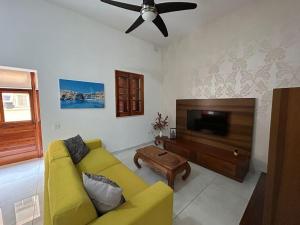 斯利马Luxurious Villa on Sliema Promenade的客厅配有黄色沙发和平面电视。